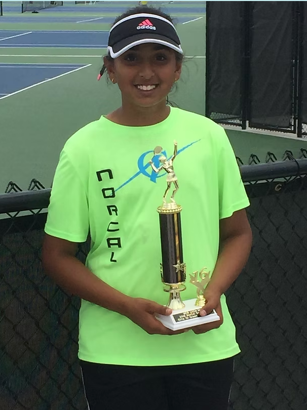 Lavanya Verma holding a tennis trophy as a child